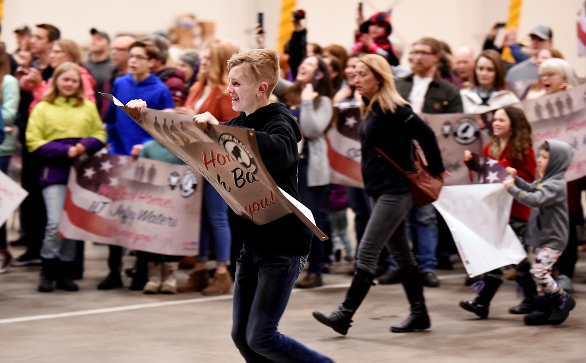 Family members start to rush as the first members of the Montana National Guard 495th Combat Sustainment Support Battalion step off the plane on Saturday night, March 16, at the Glacier Jet Center north of Kalispell. The unit has been deployed to Afghanistan since May 2018. (Brenda Ahearn/Daily Inter Lake)