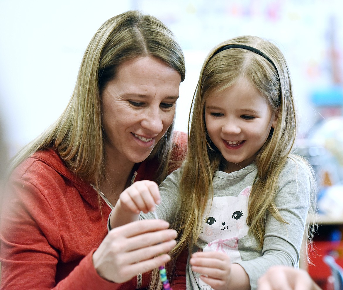 Jennifer Kalagian, right, and daughter Kinley craft a bracelet during Pre-K Pi(e) Day at Peterson Elementary on Wednesday, March 13. Pi(e) Day activities were organized by a group of preschool parents and included games and literacy activities involving numbers, counting, patterns and shapes. Russell Elementary preschool classrooms held a similar event on Thursday, March 14. (Casey Kreider/Daily Inter Lake)