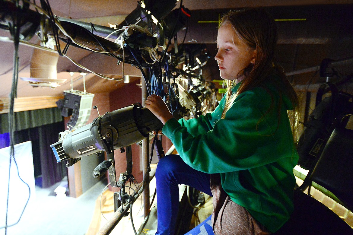 Grace Holtneyer operates a spotlight from the catwalk above the Bigfork Playhouse Children's Theatre at Bigfork Center for the Performing Arts on Wednesday, March 13. (Casey Kreider/Daily Inter Lake)