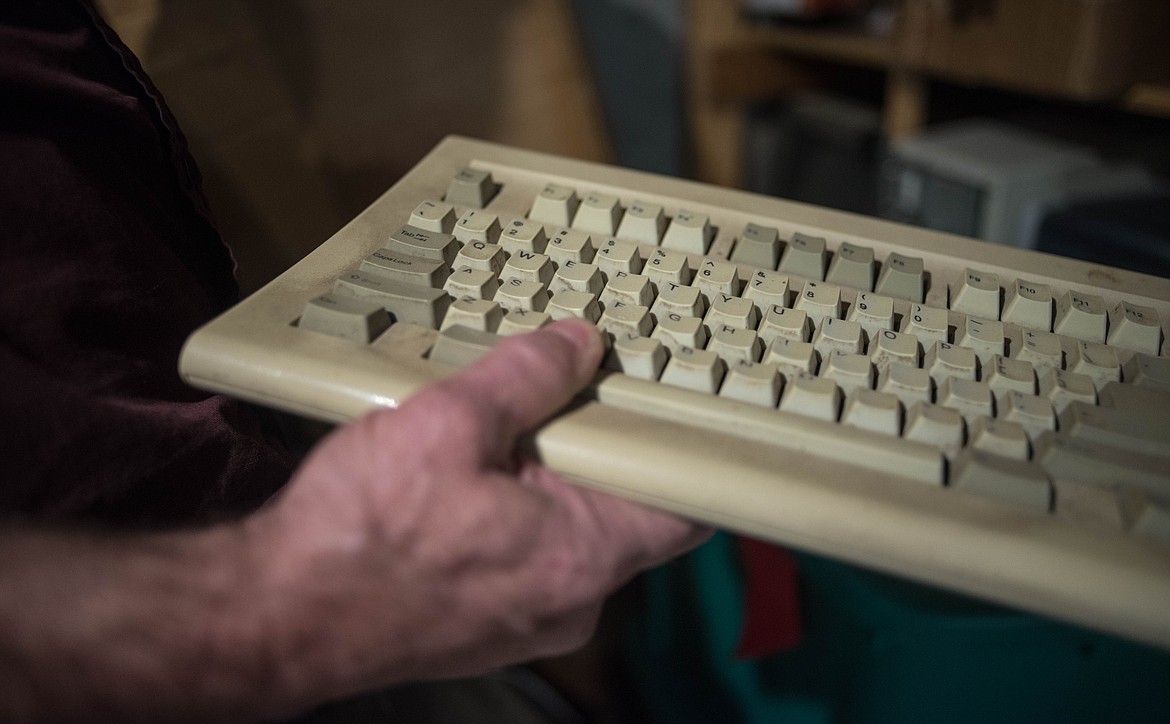 Bob Hosea unearths the first keyboard he used to start programming after being laid off as a miner, March 12 in Libby. (Luke Hollister/The Western News)