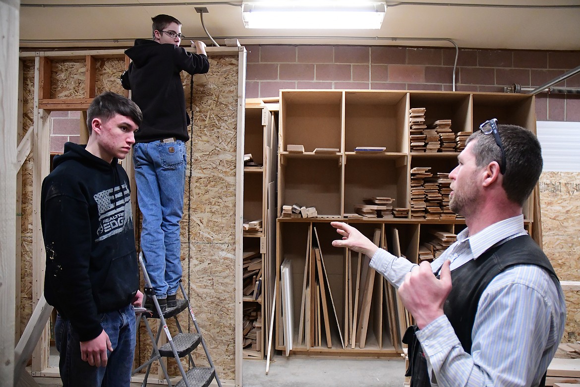 CFHS industrial arts teach Jeff Remiker, right, works with students Dakota Reeves and Cian Tuell Monday. The CFHS construction class will be building a cabins for Glacier National Park beginning next school year as part of the &quot;School to Park&quot; program. (Jeremy Weber photo)