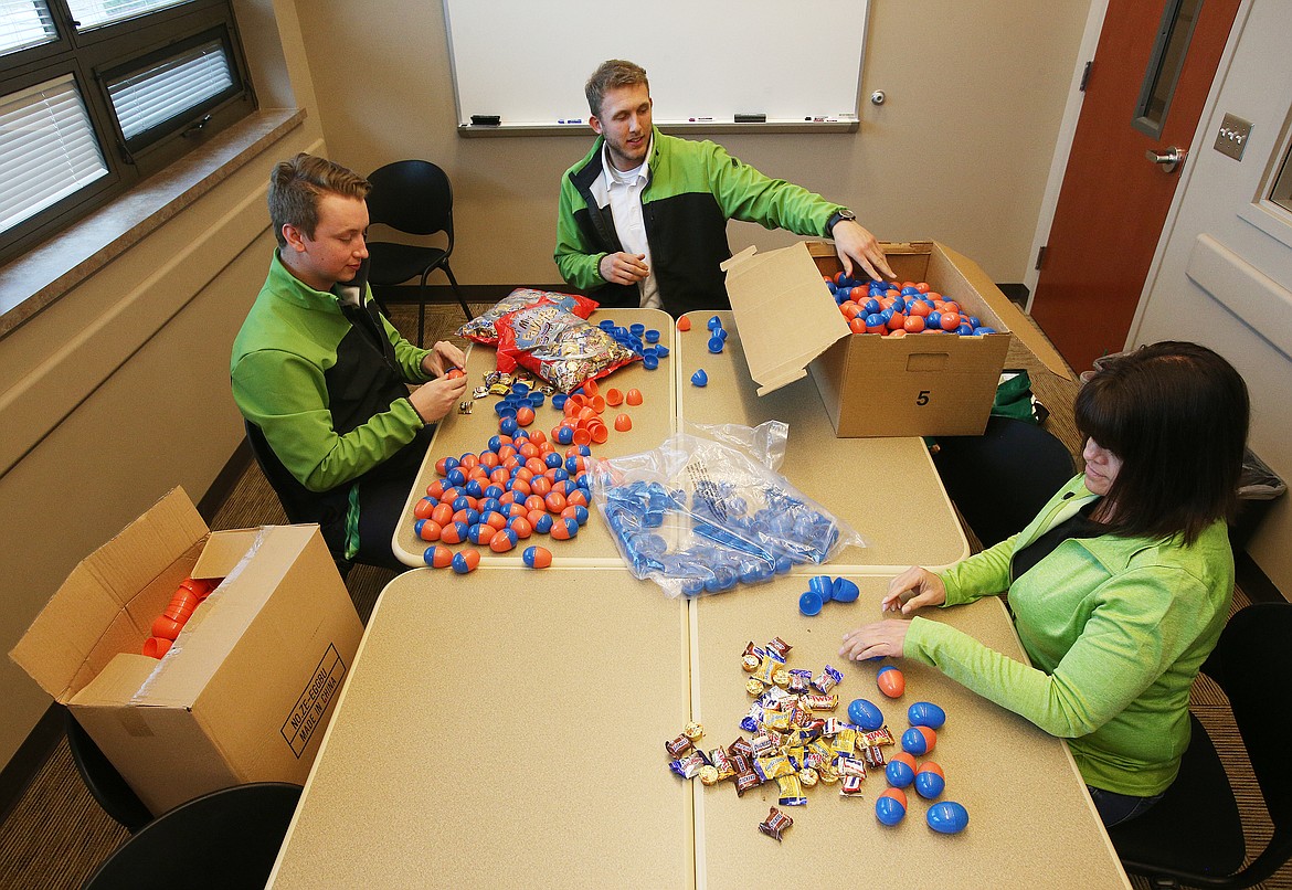 Idaho Central Credit Union employees Roman Kleng, left, Corey Koski, center, and Kelly Hagen stuff over 500 eggs with candy at Post Falls City Hall in preparation for Post Fall's Easter Egg Hunt Extravaganza on April 20 at Q'emiln Park. (LOREN BENOIT/Press)