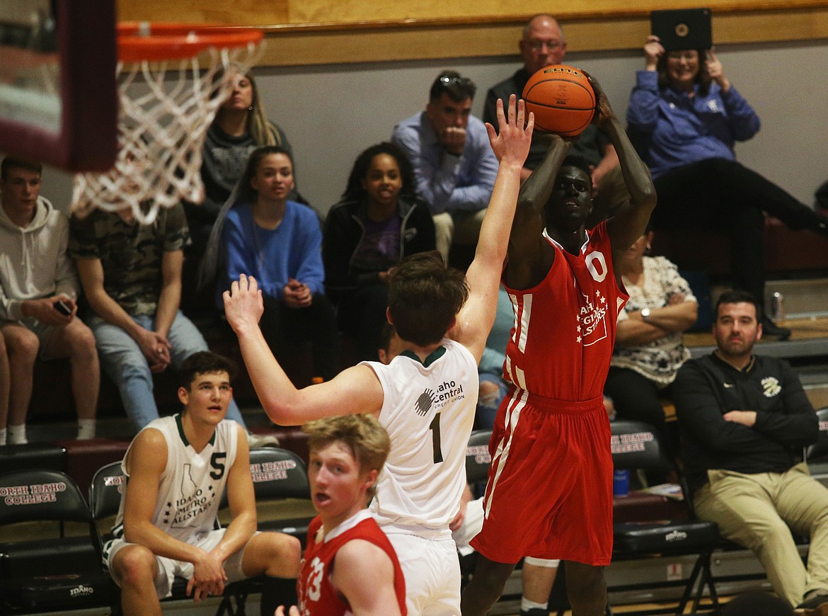 Region All-Star Kon Ajang of Genesis Prep shoots a 3 over Metro All-Star Winston Duggan of Twin Falls.