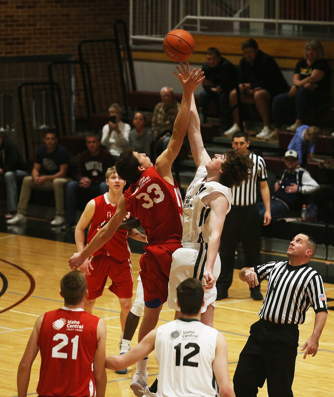 Region All-Star's Kale Edwards (33) and Metro All-Star's Mitchell Brizee, of Twin Falls, battle for the opening tip at the beginning of the 16th Annual Idaho High School All Star game Saturday at North Idaho College. (LOREN BENOIT/Press)
