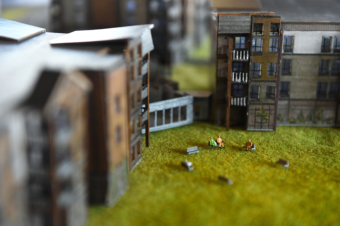 Miniature figurines sit on benches in an unfinished patio portion of an architectural model of The Woodlands, a residential community for people 55 and up, at the company&#146;s office in Kalispell on Wednesday, March 20. (Casey Kreider/Daily Inter Lake)