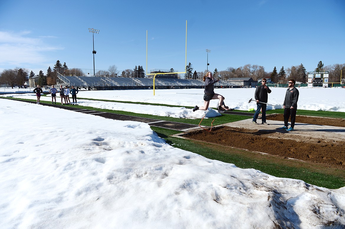 Long jumpers warm up at Flathead High School track and field practice at Legends Stadium on Thursday, March 21. Flathead coaches spent 18 hours over three days using snow blowers to clear the track and surrounding areas for athletes to practice outside. (Casey Kreider/Daily Inter Lake)