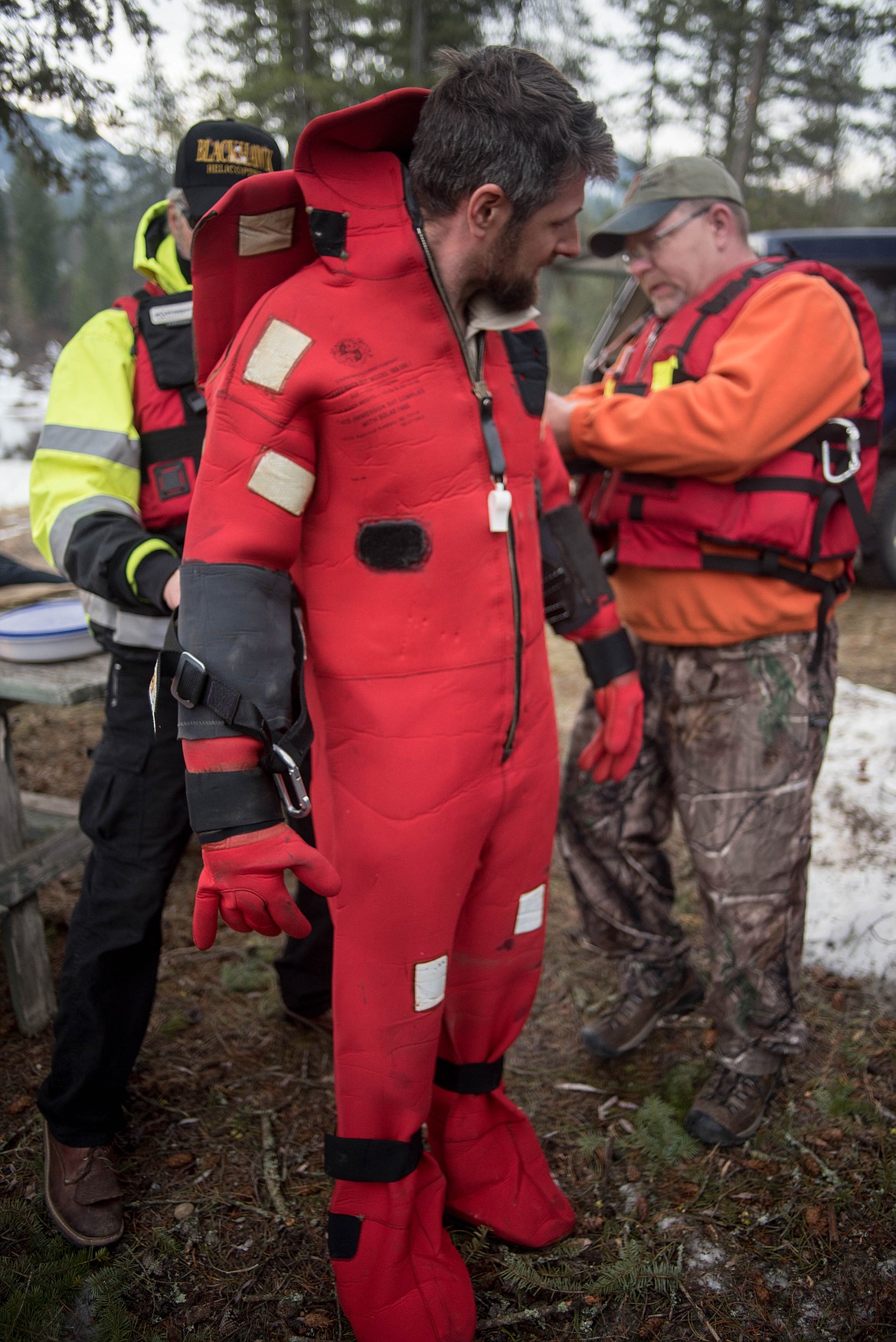 Justin Slobuszewski, gets help putting on his ice rescue suit at a seasonal rescue training exercise for David Thompson Search and Rescue crew members, Saturday at Throop Lake. (Luke Hollister/The Western News)