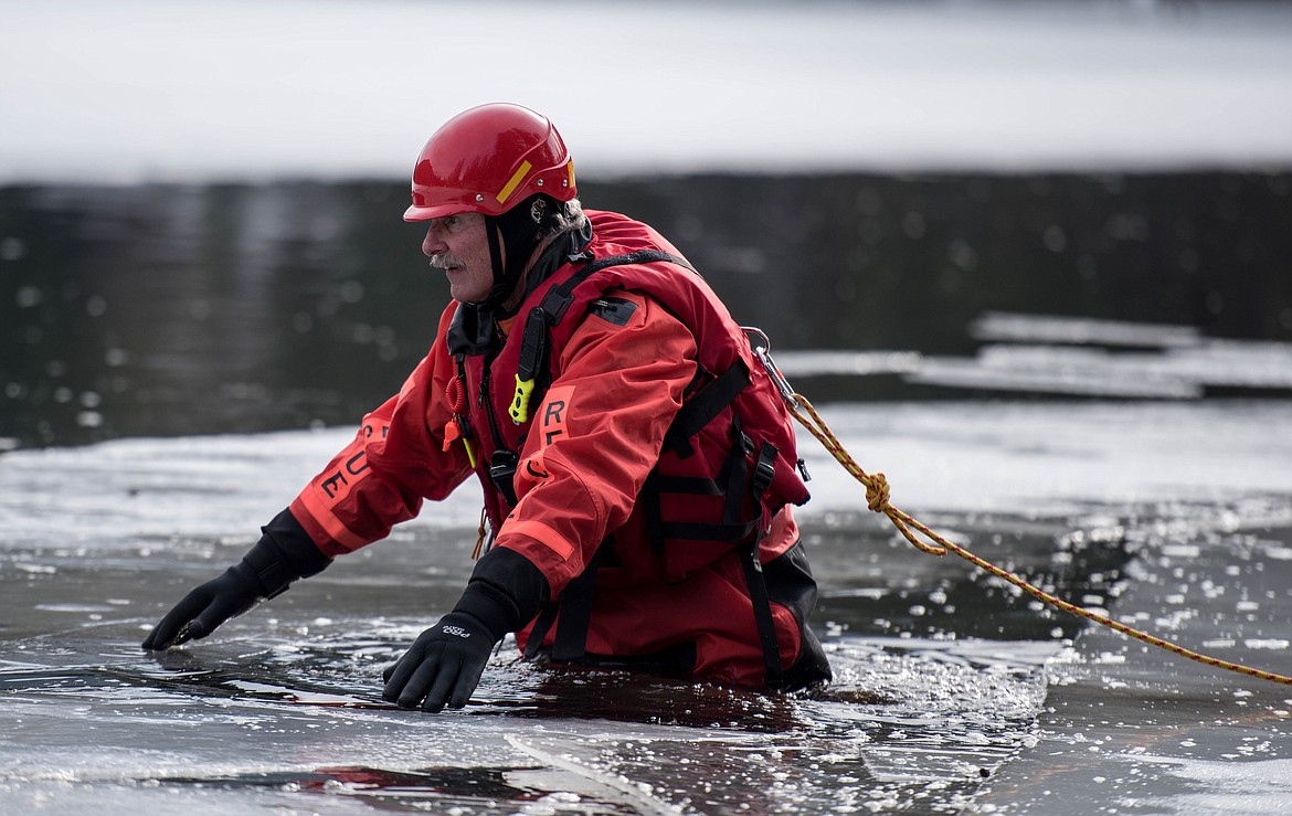 Terry Crooks wades through icy water at a seasonal rescue training exercise for David Thompson Search and Rescue crew members, Saturday at Throop Lake. (Luke Hollister/The Western News)