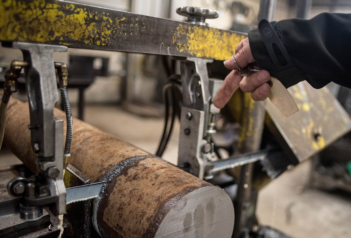 LeRoy Thom points to a metal saw, a machine he which he bought from W.R. Grace, Friday at Montana Machine &amp; Fabrication. (Luke Hollister/The Western News)