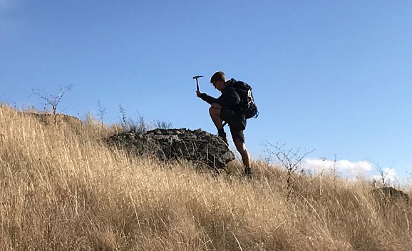 WHILE DOING field work in the Anaconda-Pintler Wilderness, Polson product Caden Howlett uses a rock hammer on a hillside.