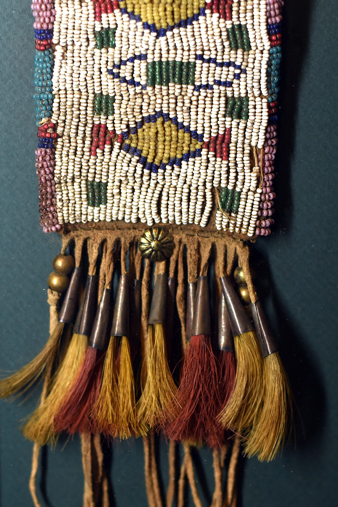 An authentic beaded bag on display under glass at the Bad Rock Settlement Museum.