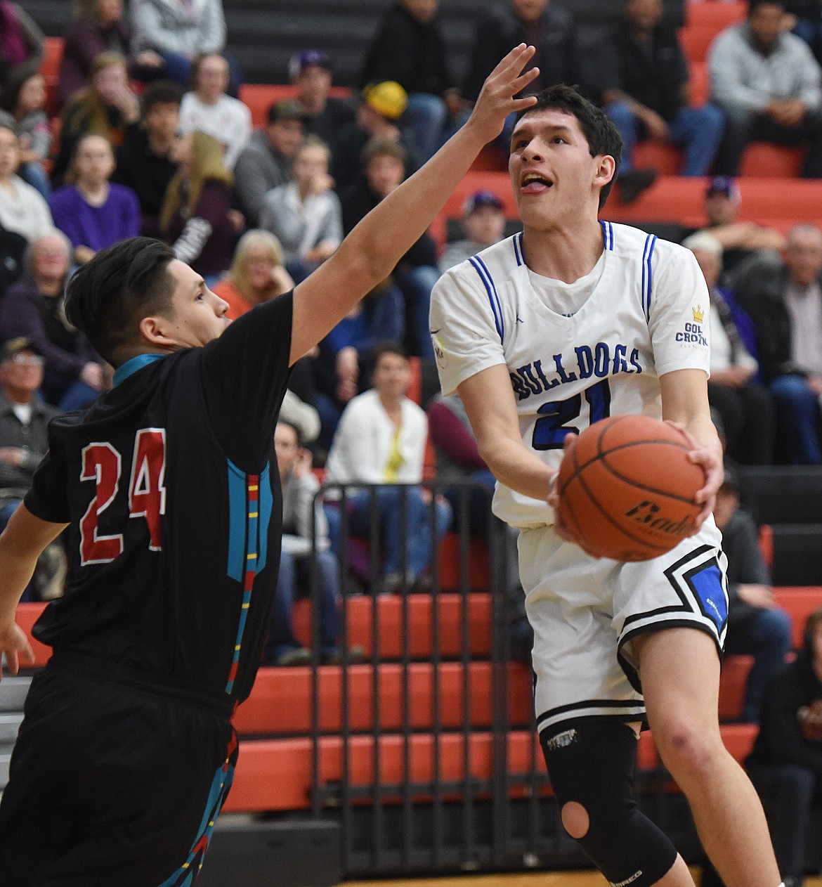 WACEY McCLURE of Mission goes up and under defender Travis Pierre of Two Eagle River during the boy&#146;s Mission Valley All-Star Game on March 21 in Ronan.