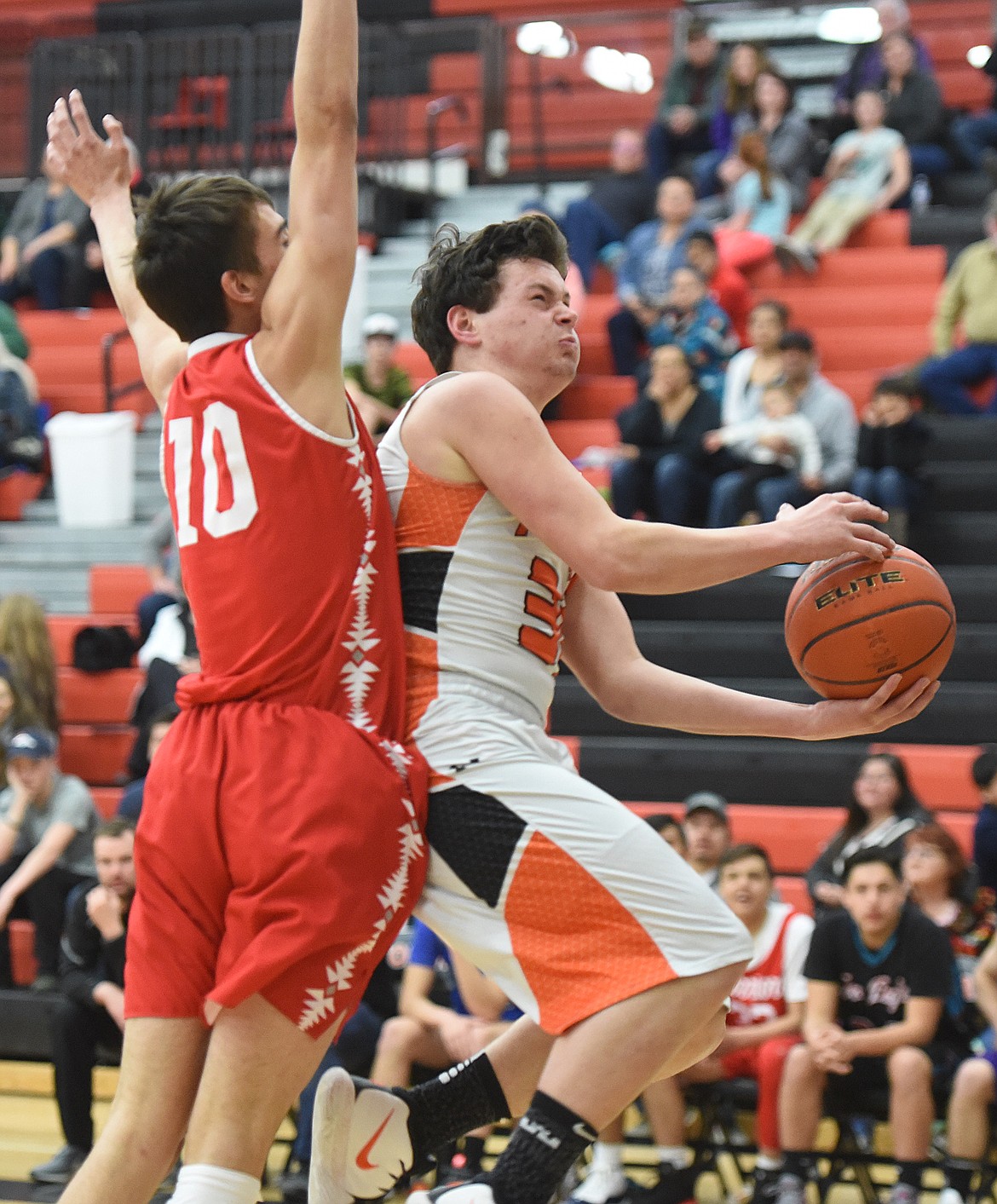 MATT McCRACKEN, a Plains senior, scoops the ball to the hoop past Lane Johnson of Arlee during the Mission Valley All-Star boys&#146; game in Ronan.