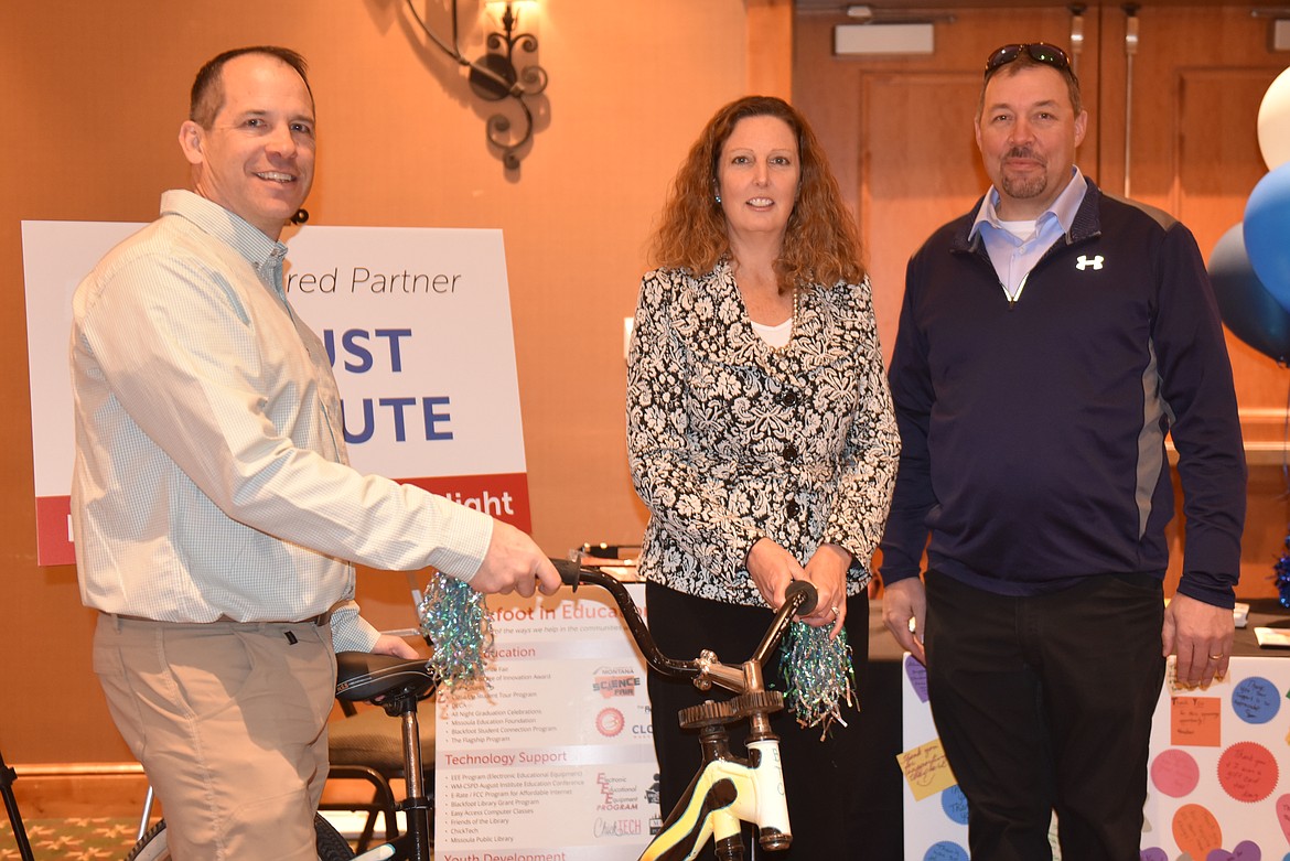 TROUT CREEK educator Daisy Carlsmith (center) directs the non-profit Western Montana Professional Learning Collaborative, which was a Featured Partner at Blackfoot Telecommunications&#146; annual meeting last Saturday, March 23. Also pictured are Jeff Crew (left) and Dean Phillips of Beyond the Chalk, popular presenters at WMPLC teacher training workshops. (Carolyn Hidy/Clark Fork Valley Press)