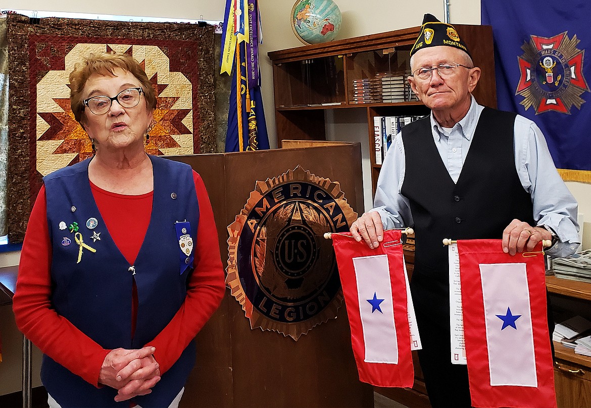 CHARLO AMERICAN Legion Post 126 Commander Robert Shaw shows two Blue Star flags presented to him by Jesse Merwin of Ronan Post 138 during the 100th birthday celebration March 20.