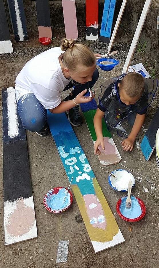 (Courtesy Photo)
An older student helps a younger student block in the colors.