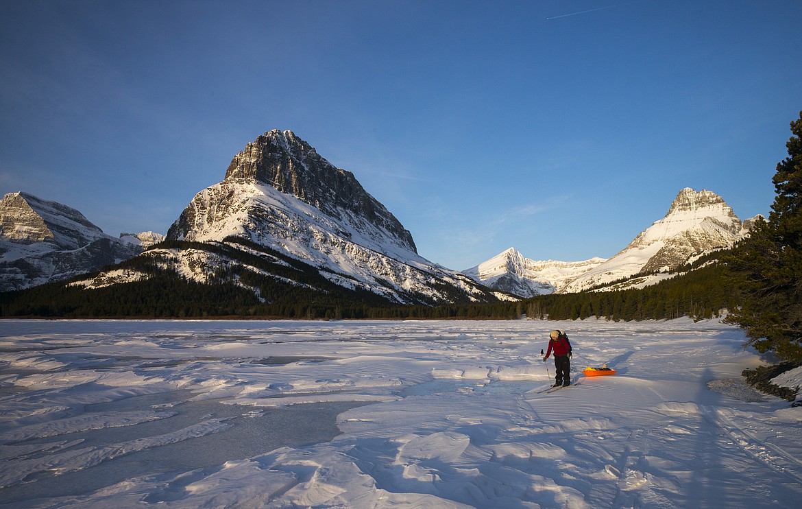 Skiing out on a frozen Swiftcurrent lake at dawn.