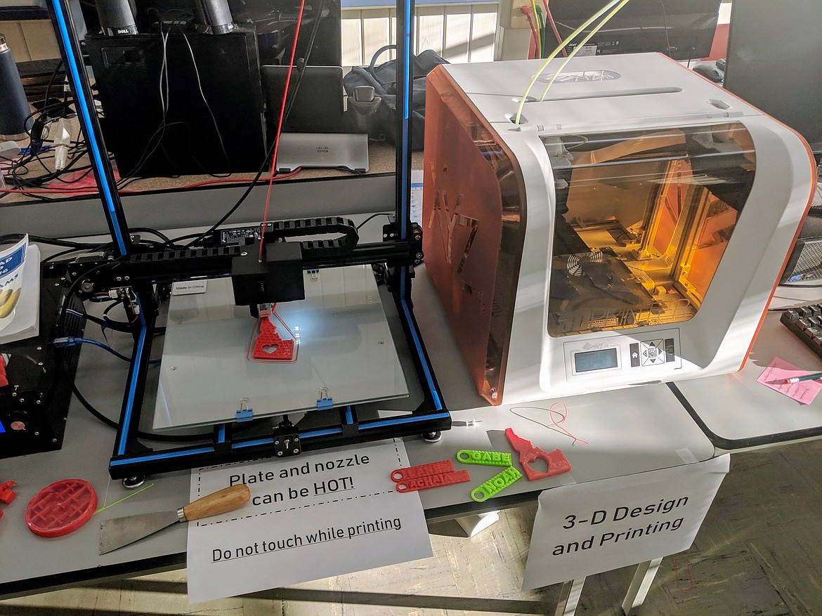 The Tinker Tech Lab&#146;s 3D printer works on a small Idaho creation. Siting next to it are name tags that were also created with the printer by second- and third-graders.