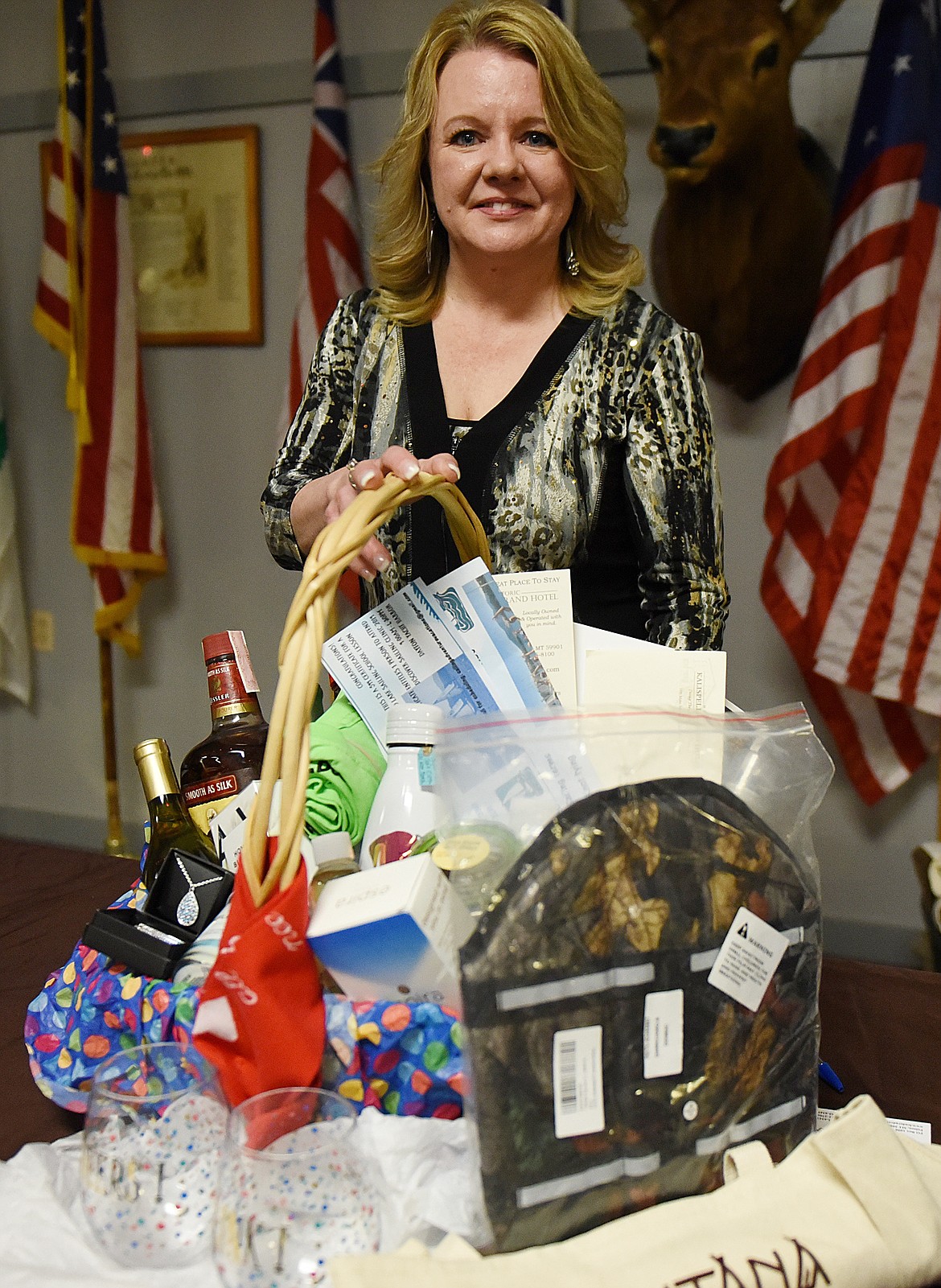 LAUNA BENSON, president of the Mission Valley Animal Shelter board, shows a large basket of goodies that was given away to culminate a raffle Saturday night at the Mission Valley Elks Lodge.