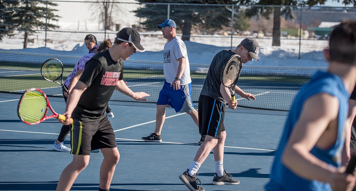 Coach Kyle Hannah runs through forehand and backhand techniques with Libby high school students, Wednesday at the local tennis courts.
