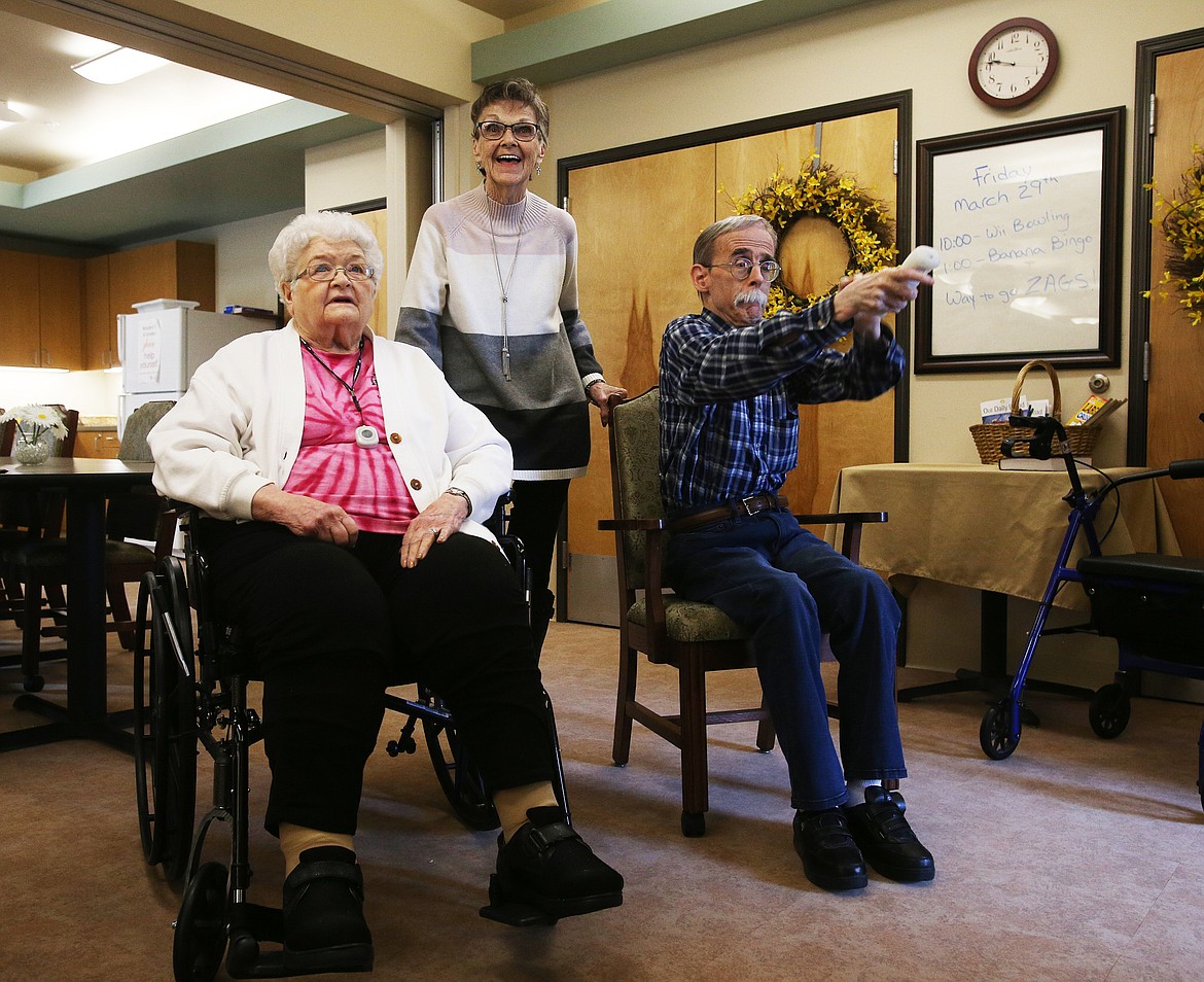 Volunteer Peggy Smith, center, and Orchard Ridge resident Shirley Freund, left, watch Mike Mooney play a couple games of Wii bowling Friday at Orchard Ridge. (LOREN BENOIT/Press)