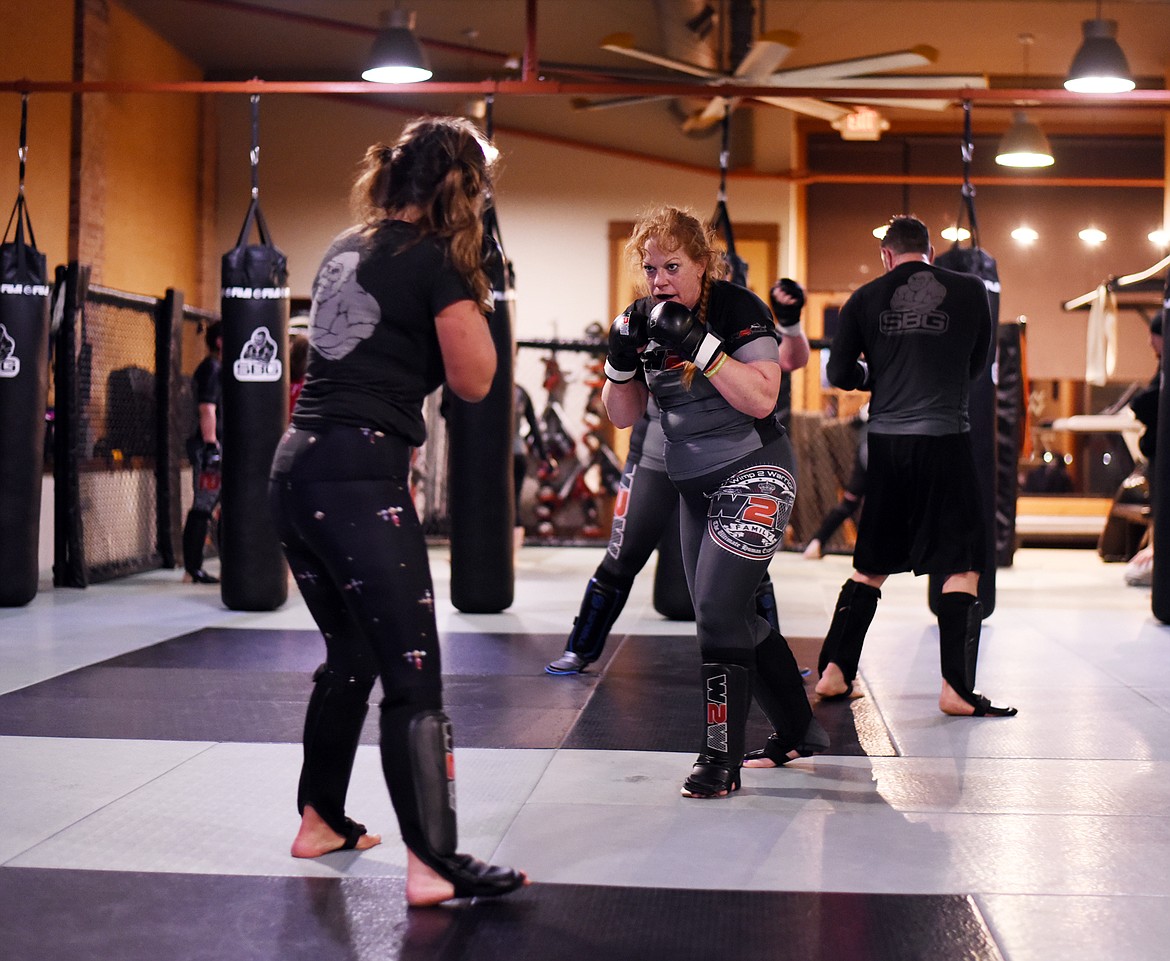 Melissa Berensten, 55, sparring with Trisha Roesler during the 6 a.m. practice session on Thursday morning, March 28, in the Wimp 2 Warrior program at Straight Blast Gym in Kalispell. Berensten said that every day she comes she thinks to herself &quot;I'm too old for this.&quot; But she keeps coming back for more. (Brenda Ahearn/Daily Inter Lake)