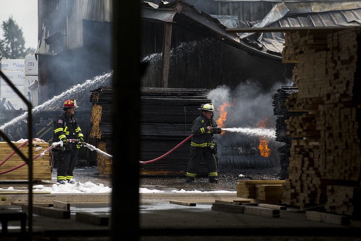 Northern Lakes Battalion Chief Kevin Croffoot, right, lends a hand to fight a fire at Merrit Bros. Lumber Company in Athol in this 2017 photo. (LOREN BENOIT/Press File)