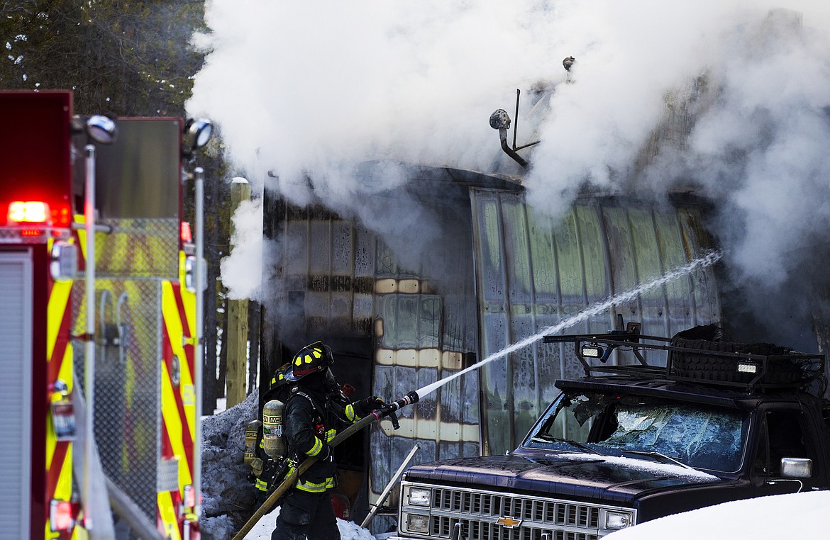 Northern Lakes firefighters drench a machine shop on Jerry Larson&#146;s property in Athol in this 2017 photo. (LOREN BENOIT/Press File)