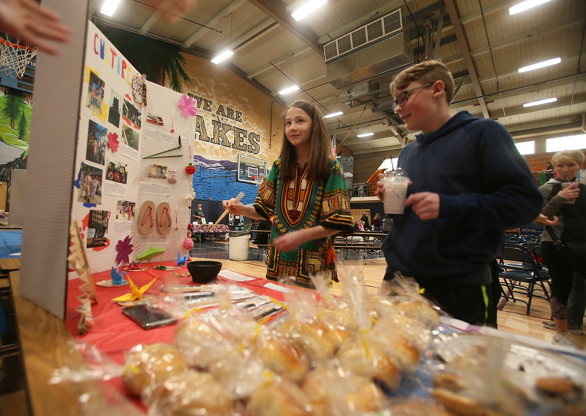 Hattie Owens, 12, of Coeur d&#146;Alene, tries her hand at moving jelly beans with chopsticks as she and her cousin Scout Owens, 13, visit a Japanese informational booth during the Community Multicultural Faire on Saturday.

DEVIN WEEKS/Press
