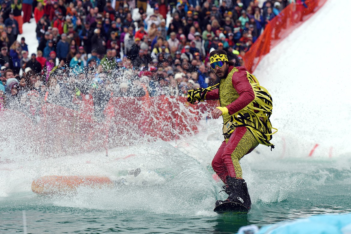 Jacob Prestegaar, dressed as former WWE wrestler Macho Man Randy Savage, skims across the water during the 2019 Whitefish Pond Skim at Whitefish Mountain Resort on Saturday. (Casey Kreider/Daily Inter Lake)