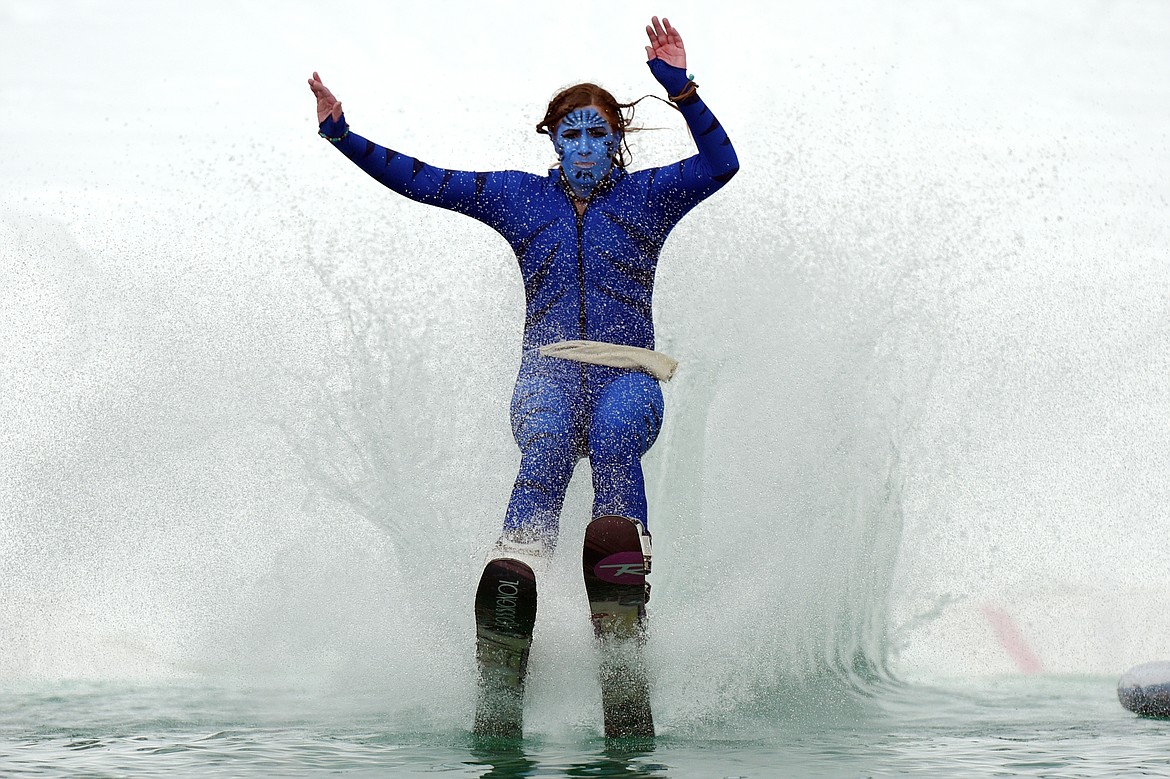 Cassie Heitz skims across the pond wearing a costume her late father, Jack &quot;Rad Jack&quot; Marcial, used to wear during past pond skims at the 2019 Whitefish Pond Skim at Whitefish Mountain Resort on Saturday. (Casey Kreider/Daily Inter Lake)