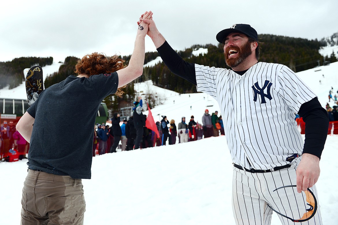 Brothers Shane, left, and Billy Marcial celebrate after successful trips across the pond during the 2019 Whitefish Pond Skim at Whitefish Mountain Resort on Saturday. Billy Marcial is wearing the New York Yankees Mickey Mantle jersey worn by his late father Jack &quot;Rad Jack&quot; Marcial while he competed in the pond skim. (Casey Kreider/Daily Inter Lake)
