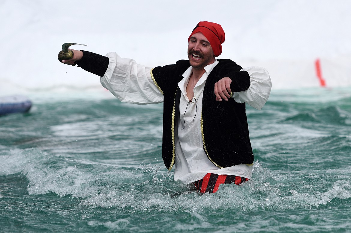 A competitor dressed as a pirate doesn't quite make it across the pond  during the 2019 Whitefish Pond Skim at Whitefish Mountain Resort on Saturday. (Casey Kreider/Daily Inter Lake)