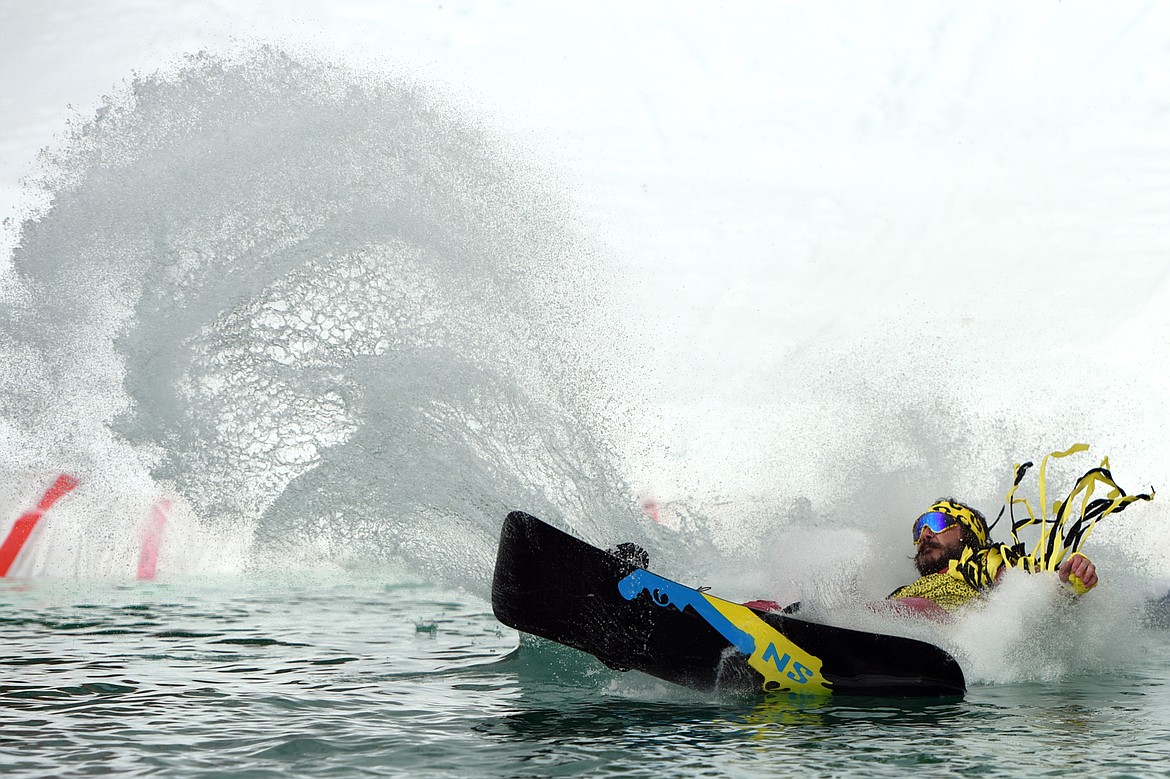 Jacob Prestegaar, dressed as former WWE wrestler Macho Man Randy Savage, crashes into the water during the 2019 Whitefish Pond Skim at Whitefish Mountain Resort on Saturday. (Casey Kreider/Daily Inter Lake)