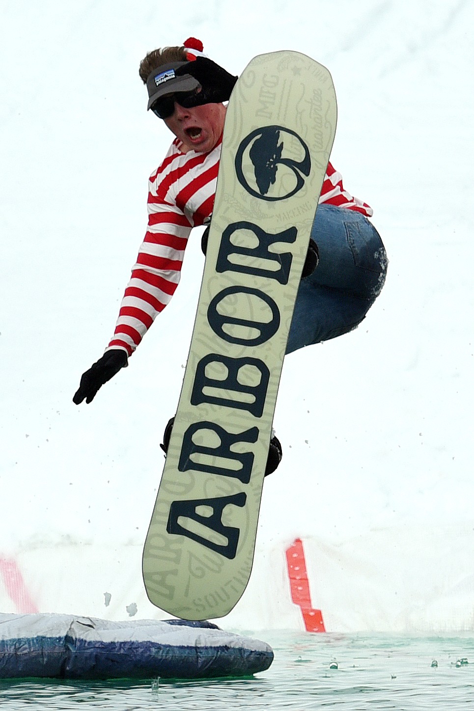 Garrett Webb, dressed as Waldo, crashes into the pond during the 2019 Whitefish Pond Skim at Whitefish Mountain Resort on Saturday. (Casey Kreider/Daily Inter Lake)