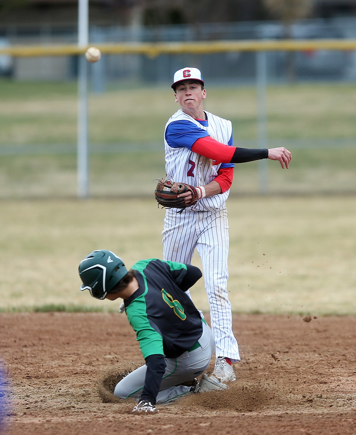 Lakeland's Nicolas Welch tries to breakup a double play and is called out as Coeur d'Alene's Jake Brown throws to first to complete the play in Wednesday's game at Coeur d'Alene High. (LOREN BENOIT/Press)