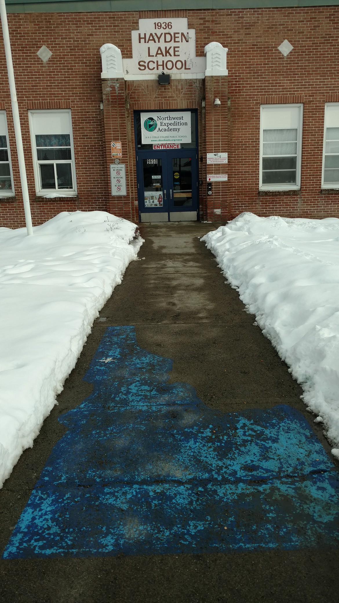 DEVIN WEEKS/Press
Fading blue paint in the shape of Idaho greets those who visit Northwest Expedition Academy, housed in the old Hayden Lake School on Government Way. The Coeur d&#146;Alene School District does not yet have any plans for the site once NExA moves into the new school on Prairie Avenue next year. The entrance to the old Hayden School is seen here amid snow mounds Feb. 20.