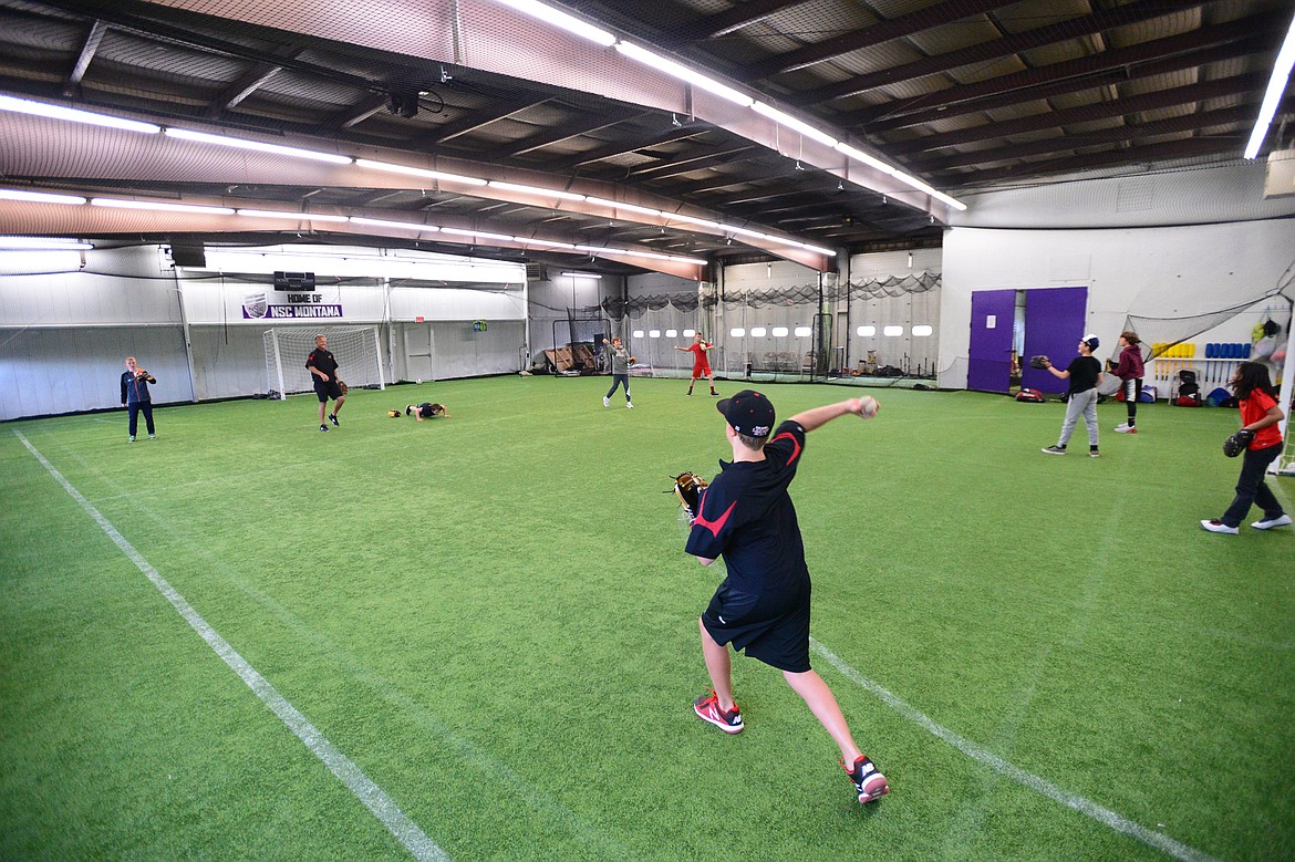 Players with the Kalispell Lakers 12U team warm up their arms before a workout at THE FORT, an indoor multi-sport turf facility in Kalispell, on Thursday, April 4. (Casey Kreider/Daily Inter Lake)