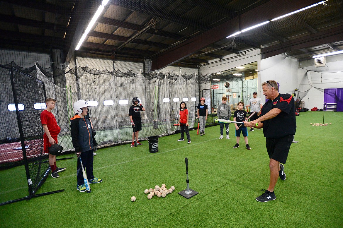Jeff Berke, a coach with the Kalispell Lakers 12U team, emphasizes proper swing mechanics before the team begins batting practice at The Fort, an indoor multi-sport turf facility in Kalispell, on Thursday, April 4. (Casey Kreider/Daily Inter Lake)