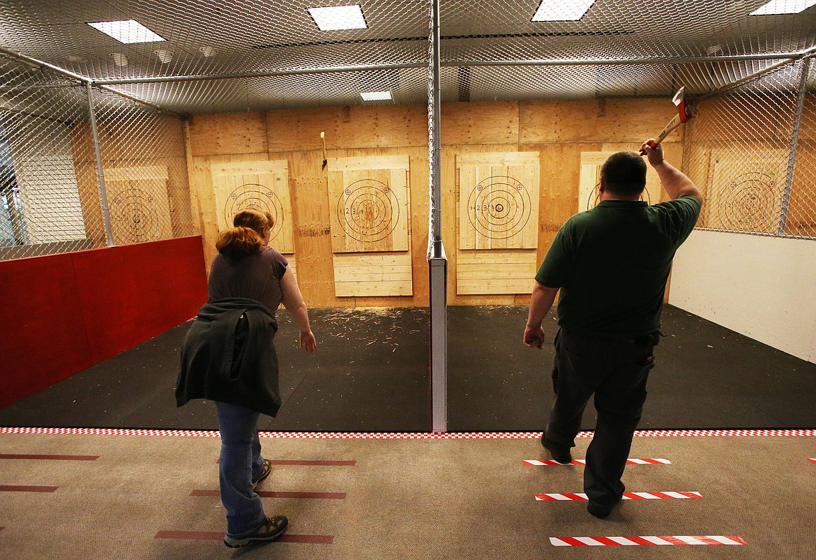 Dad and daughter duo Caitlynn and Anthony Nichols throw axes at the new Axe Force One business in the Silver Lake Mall in Coeur d'Alene on Wednesday. (LOREN BENOIT/Press)