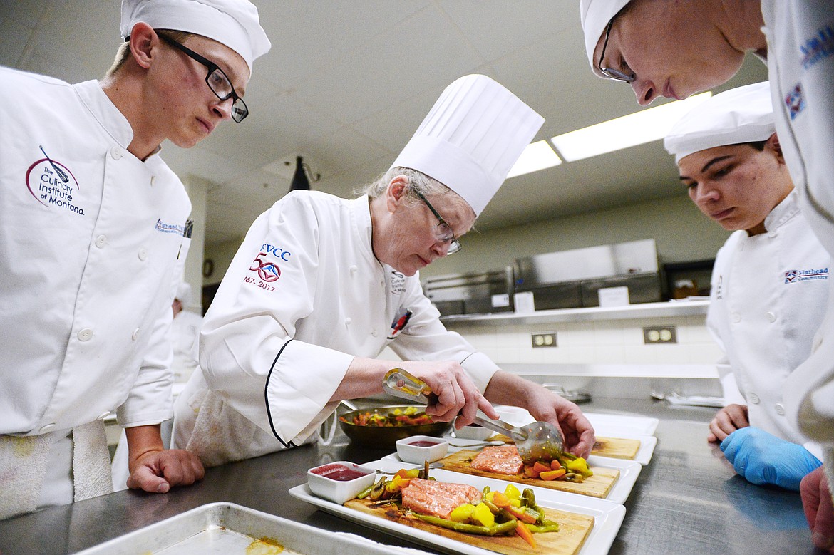 Chef instructor Manda Hudak, center, works on plating techniques with students, from left, Brant Barnes, Eli Valadez and Hannah Troutt inside the kitchen at the Culinary Institute of Montana at Flathead Valley Community College on Wednesday, April 3. (Casey Kreider/Daily Inter Lake)