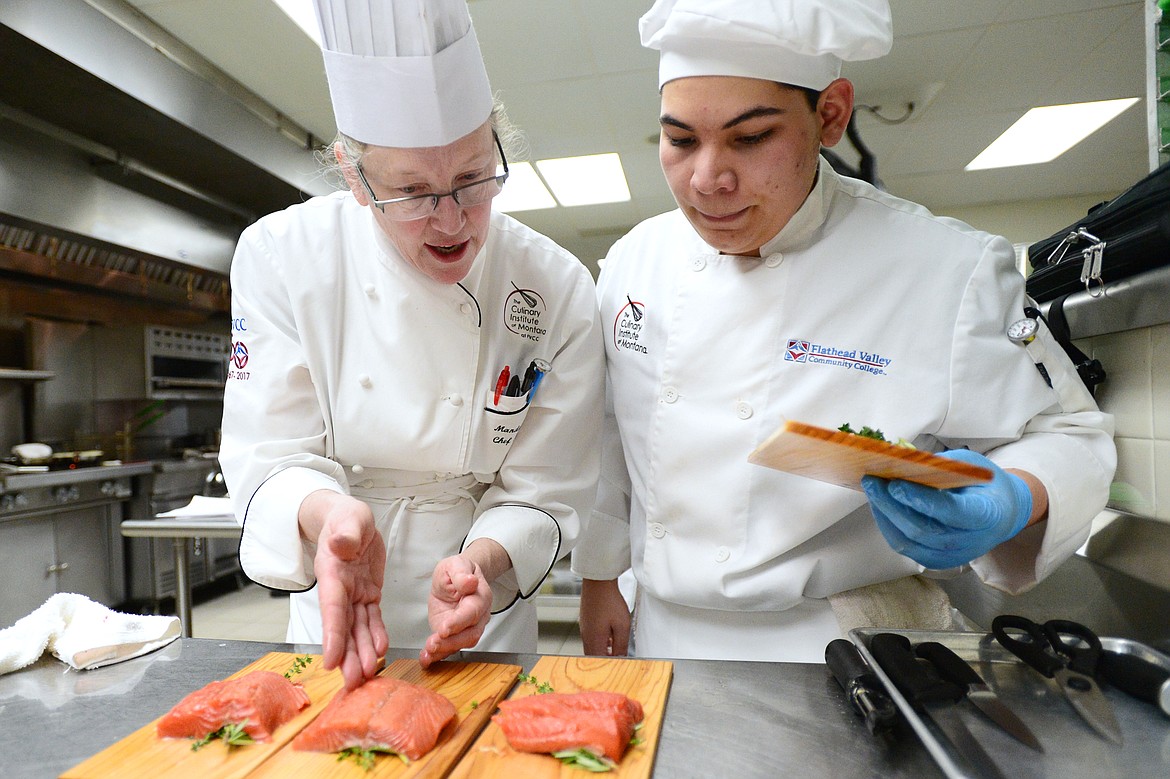 Chef instructor Manda Hudak, left, provides a few pointers to Eli Valadez as he works on his salmon dish inside the kitchen at the Culinary Institute of Montana at Flathead Valley Community College on Wednesday, April 3. (Casey Kreider/Daily Inter Lake)