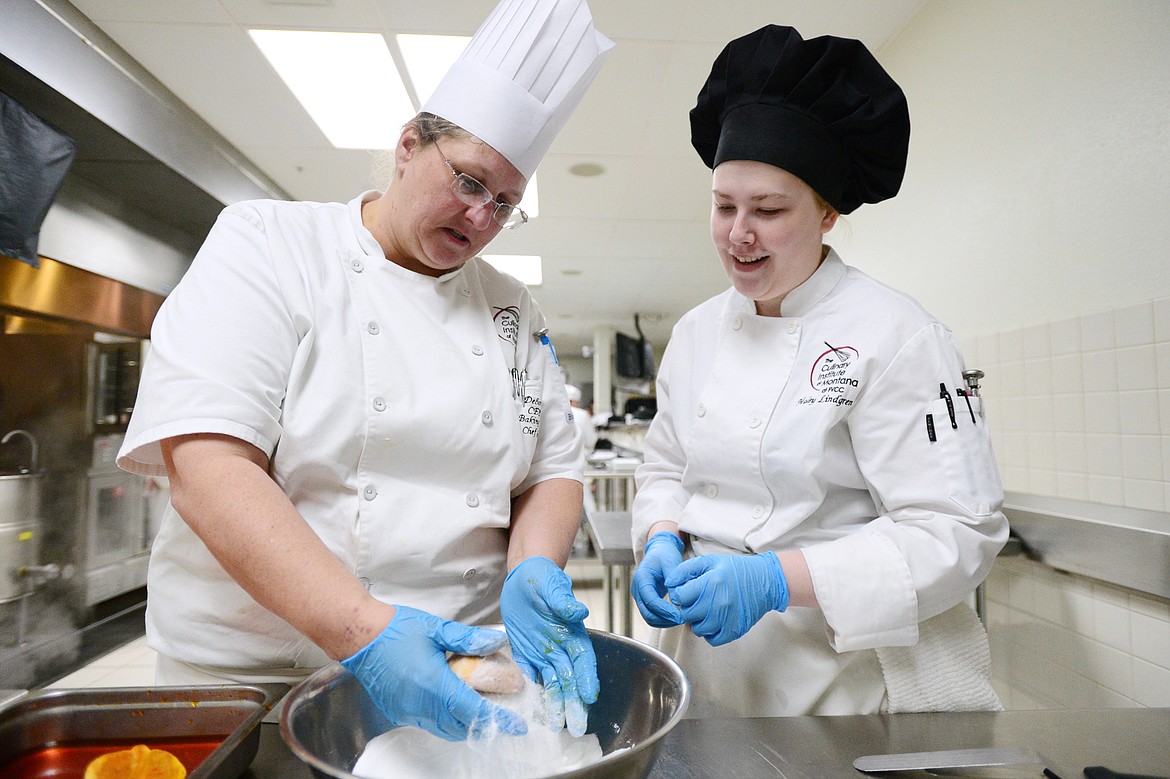 Baking and pastry chef instructor Deborah Misik, left, works with Haley Lindgren applying sugar to Italian peach cookies called pesches inside the kitchen at the Culinary Institute of Montana at Flathead Valley Community College on Wednesday, April 3. (Casey Kreider/Daily Inter Lake)