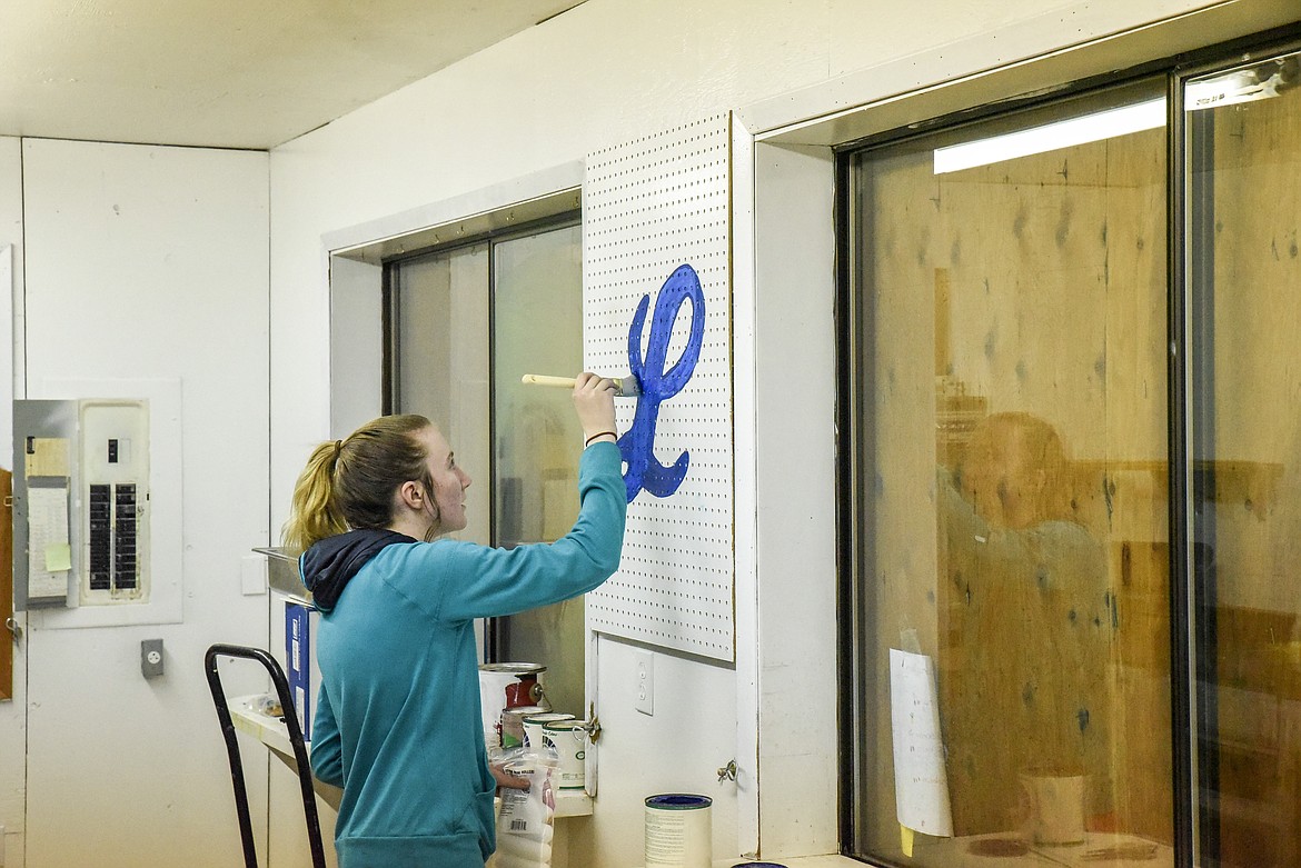 MacKenzie Foss fills in the Logger &quot;L&quot; on the inside of the concession stand Sunday evening. The new pegboards were just one of many improvements donated in the community outpouring of support following the vandalism at Lee Gehring field last weekend. (Ben Kibbey/The Western News)