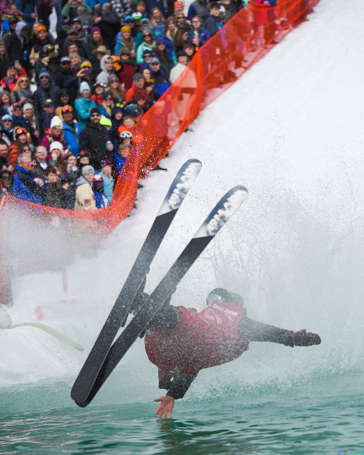 Rob Brekke, dressed as &#147;hot sauce,&#148; takes a not-so-hot fall during the 2019 Pond Skim on Saturday at Whitefish Mountain Resort. (Daniel McKay/Whitefish Pilot)
