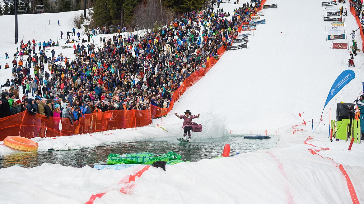 Anna Byrd, dressed as a bootlegger, clears the pond as the crowd watches during the 2019 Pond Skim on Saturday at Whitefish Mountain Resort. (Daniel McKay/Whitefish Pilot)