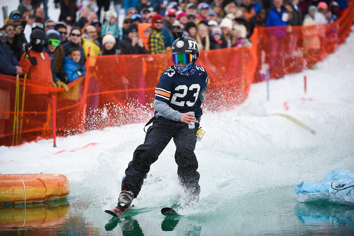 A RedBull-carrying skier easily crosses the pond during the 2019 Pond Skim on Saturday at Whitefish Mountain Resort. (Daniel McKay/Whitefish Pilot)