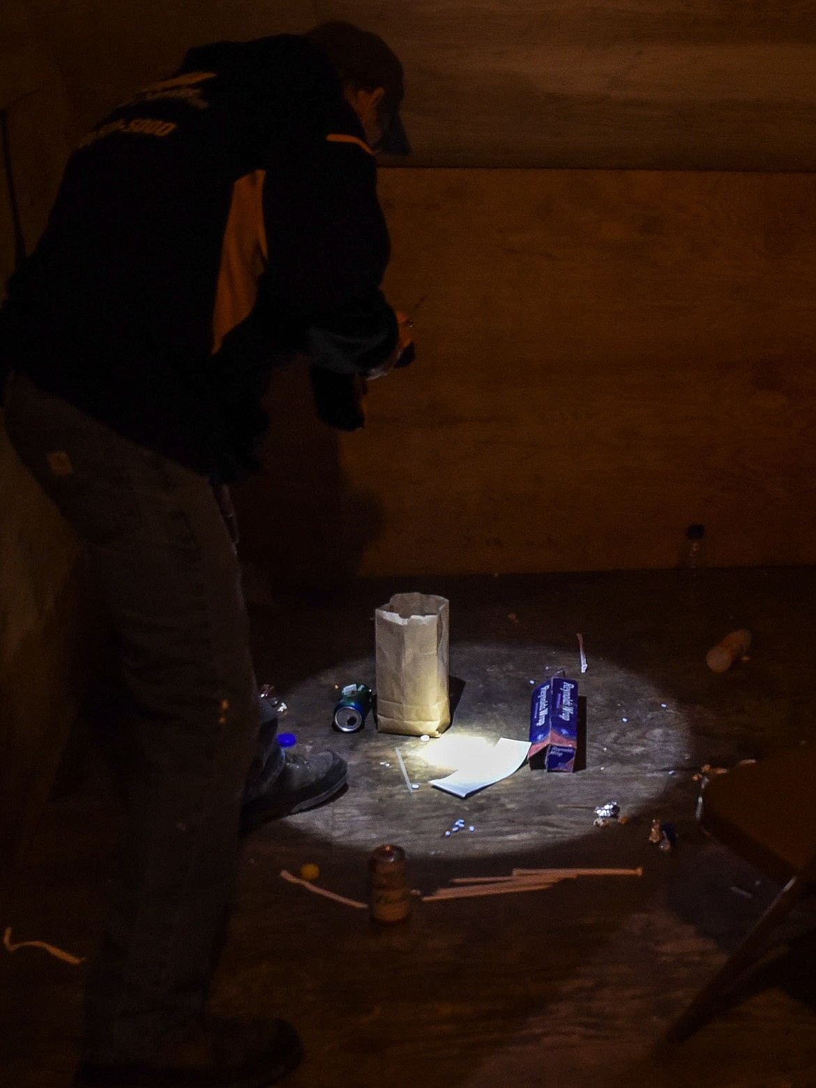 Libby Assistant Chief/Fire Marshall Steve Lauer examines beer cans and other trash left in the upstairs training area used by the Libby Volunteer Fire Department above the concession stand at Lee Gehring Memorial Field Monday. (Ben Kibbey/The Western News)