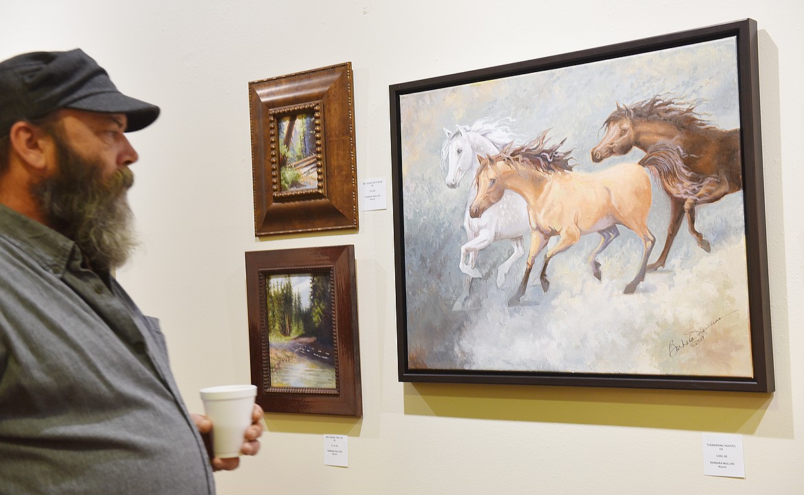 PARADISE ARTIST Steve Eberhardt takes in the fine work of Noxon&#146;s Barbara Mullins during Art on the Walls at Clark Fork Valley Hospital. (Carolyn Hidy photos/Clark Fork Valley Press)