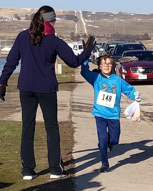 JACKSON BONTADELLI finishes the March Meltdown 5A race with a bag of eggs collected along the course in Polson.